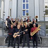 Personen mit Musikinstrumenten stehen auf einer Treppe 